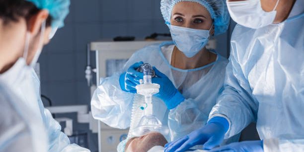 Female nurses putting oxygen mask on patient in operation room. Pre oxygenation for general anesthesia. Surgery equipment